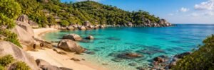 Koh Tao-inspired rocky cove with turquoise water and forested slopes