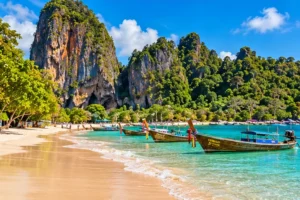 Illustration of longtail boats beneath limestone cliffs on the Krabi coast